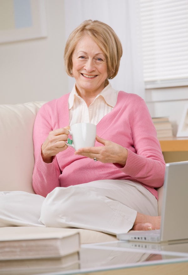 happy senior woman sitting on couch